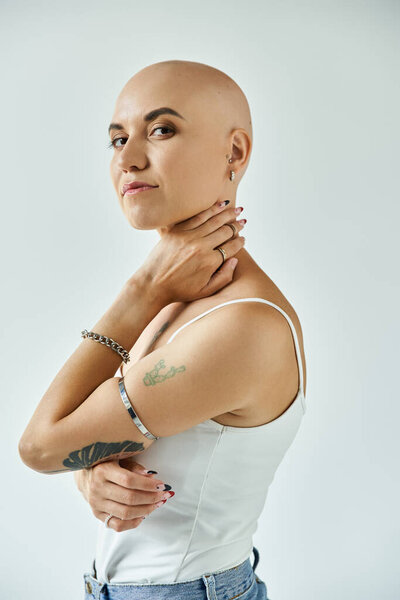 The young woman with alopecia stands elegantly, showcasing her confidence and unique beauty.