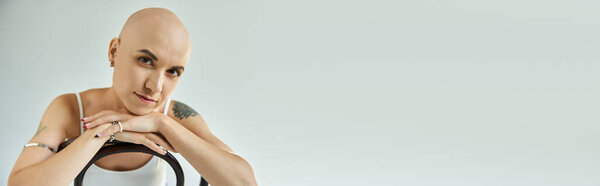 Молодая лысая женщина с облысением показывает свою уверенность в спокойной и художественной среде.