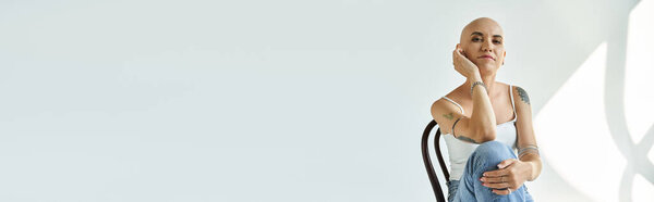 Молодая женщина с облысением элегантно позирует в тихом помещении, демонстрируя уверенность.