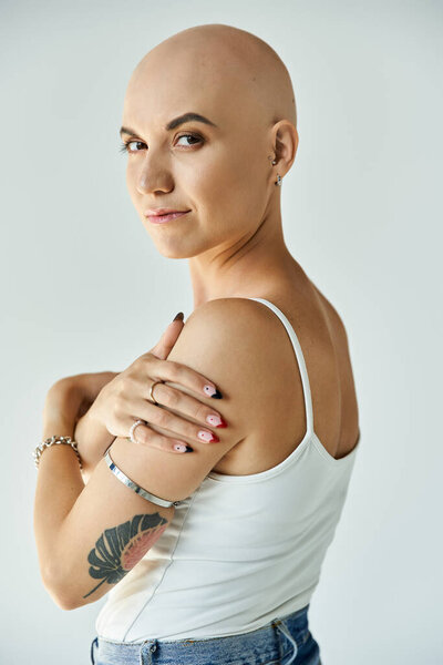 The young bald woman embraces her unique beauty, showcasing elegance and strength.