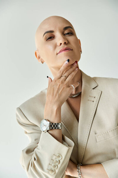 Уверенная в себе молодая лысая женщина изящно позирует, демонстрируя свою элегантность и силу.