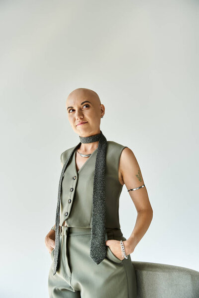 A confident young bald woman showcases her unique beauty in a chic ensemble.