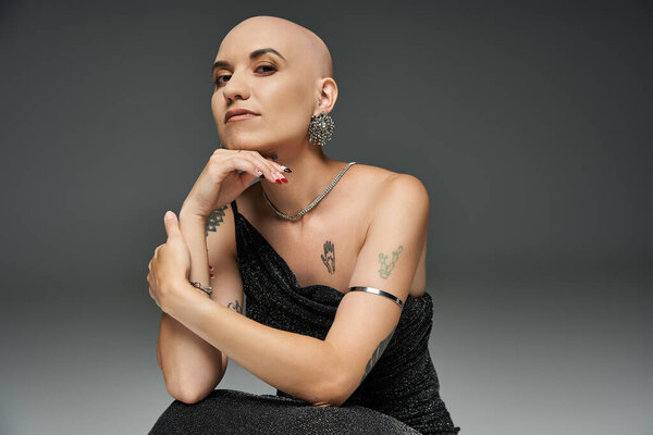 A young bald woman radiates confidence and beauty in her unique style.