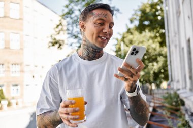 Neşeli genç bir adam evinde rahatlar, bir içki içer ve akıllı telefonuyla meşgul olur..