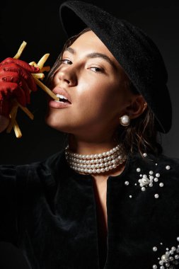 Güzel bir kadın kendine güvenerek poz verir. Patates kızartması, zarafet ve modaya uygun bir cazibe sergiler..