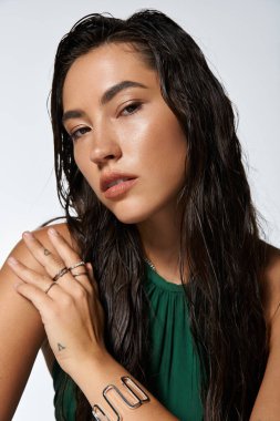 Sofistike genç bir kadın güzelliğini ve zarafetini ıslak saçlarıyla ve şık kıyafetleriyle sergiliyor..