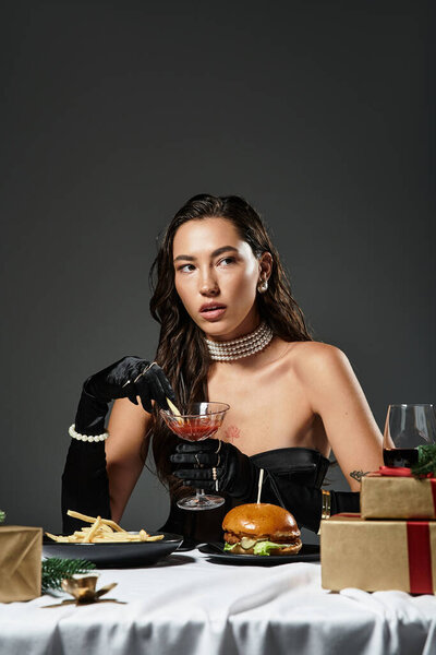 A young beautiful woman in an elegant outfit savors a cocktail while surrounded by gourmet food.