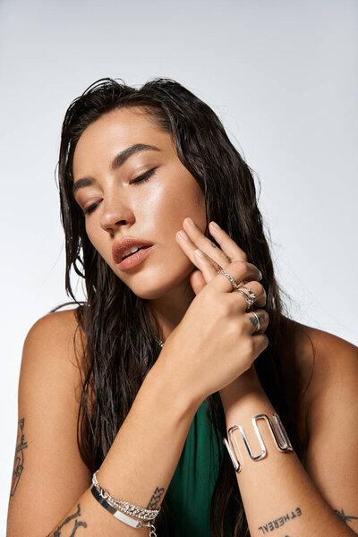 Молодая красивая женщина изящно позирует, подчеркивая ее элегантный наряд и потрясающие украшения.