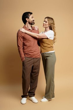 A couple stands together, expressing affection and connection through their body language. clipart