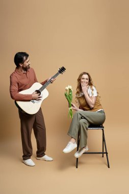 Sıcak bir atmosferde elinde çiçekler tutan bir kadın için gitar çalan bir adam için neşeli bir an yaşanıyor..