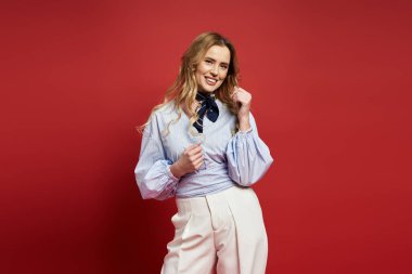 Neşeli orta yaşlı bir insan kırmızı arka plan önünde şık kıyafetler giymekten zevk alır..