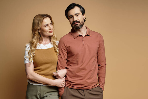 Пара наслаждается нежными объятиями, излучающими любовь и связь на нейтральном фоне.