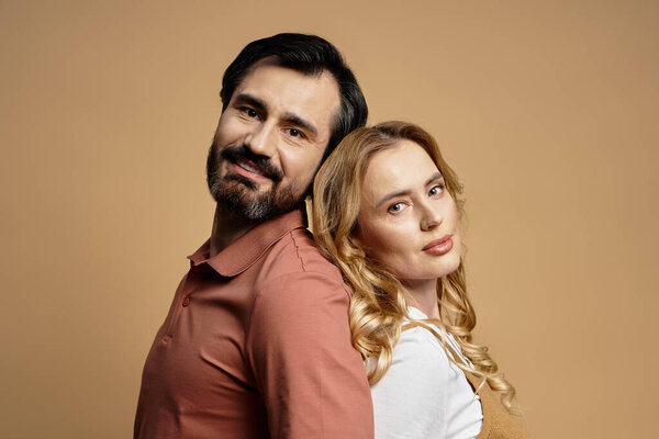 Радостная пара стоит спиной к спине, излучая тепло и связь в своих позах.