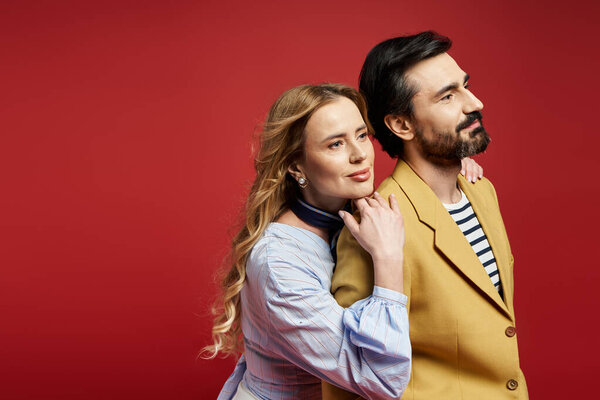 Пара средних лет разделяет нежный момент, окруженный ярким малиновым фоном.