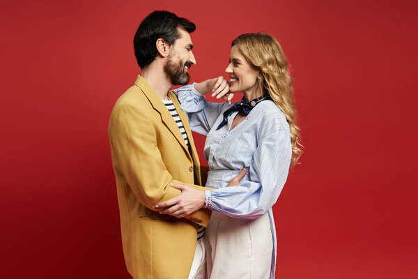 A joyful middle aged couple embraces while enjoying each others company in a vivid setting.