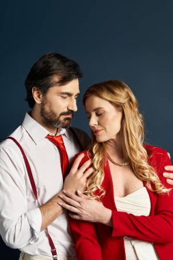 Şefkatle kucaklaşan orta yaşlı bir çift resmi kıyafetleriyle sevgilerini ve ilişkilerini sergiliyorlar..