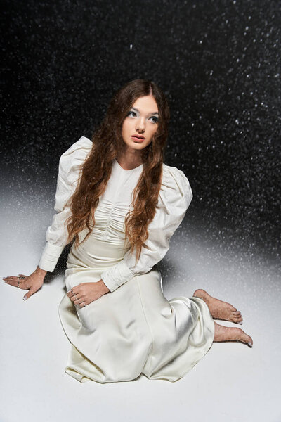 Молодая женщина в плавном платье созерцает тихо, как свет сверкает вокруг нее.