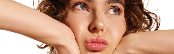 Молодая женщина демонстрирует эмоциональное выражение своим вдумчивым взглядом и мягким прикосновением.