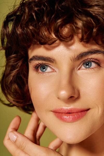 A young woman with dynamic curls radiates happiness, captured in a moment of reflection and grace.