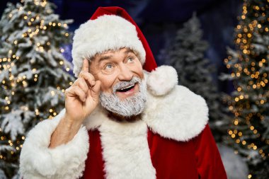 Noel Baba karlı ağaçların ve parıldayan ışıkların arasında gülümser, bayram neşesini yayar..