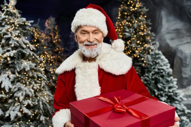 Noel Baba neşeli bir şekilde karlı, şenlikli bir ormanda hediye sunar..