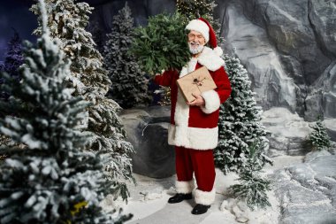 Noel Baba 'nın neşeli bir figürü elinde paketlenmiş bir hediyeyle ebediyen yeşil ağaçların arasında duruyor..
