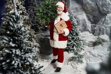 Noel Baba hediyeleri ve yemyeşil yeşillikleri neşeyle dolu karlı bir arazide taşır..