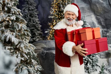 Noel Baba bayram neşesini yayar ve neşeli bir manzaranın içinde parlak hediyeler taşır..