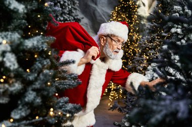 Güzel süslenmiş ağaçların arasında, Noel Baba sessizce çocuklar için Noel hediyeleri düzenler..