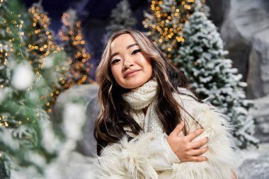 Işıklarla dolu karlı kış harikalar diyarında bir insan Noel 'in büyüsünü kucaklıyor..