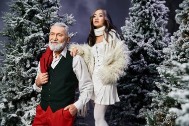 Kış mevsiminde şık bir çift, Noel 'de her yer karla kaplıyken poz verir..