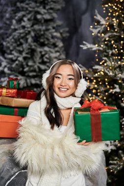 Kışın süslenmiş bir Noel ağacıyla çevrili bir hediye tutan ve hediyeler veren biri..