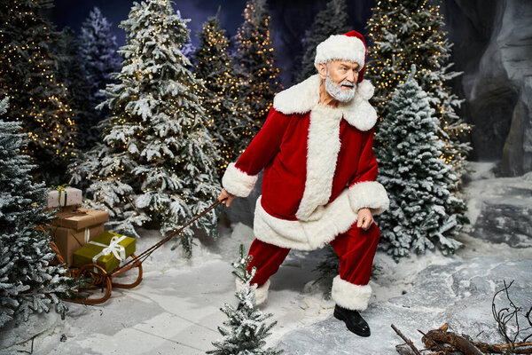 Веселая фигура в красном костюме тащит сани, полные подарков, сквозь снежные деревья.