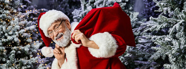 Санта-Клаус тепло улыбается, неся с собой большую сумку с подарками в зимней стране чудес.