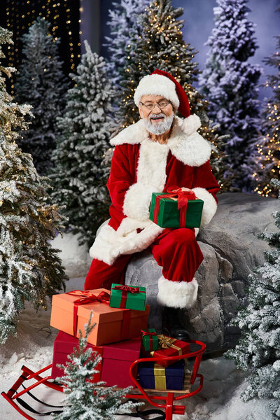 A joyful Santa sits among colorful gifts, spreading holiday cheer in a snowy scene.