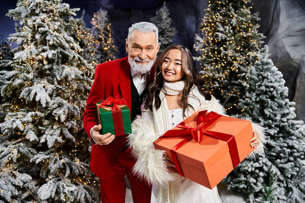 Два веселых лица держат красиво обернутые подарки в окружении праздничных украшений.