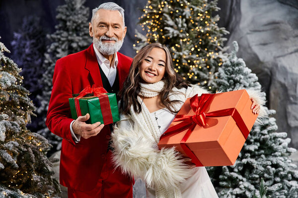 Пара обнимает дух праздника, держа красочные подарки на фоне зимних чудес.