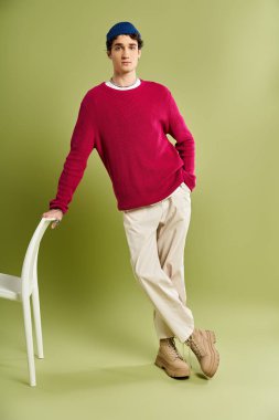 Yakışıklı genç bir adam pembe bir kazakla rahat ama modaya uygun bir hava sergiliyor..