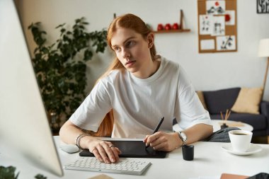 Odaklanmış genç bir adam, parlak ve çağdaş bir ofis alanı yaratmak için tablet kullanır..