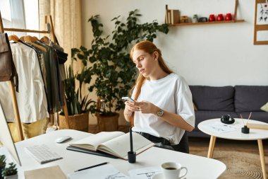 Genç bir adam sanatsal unsurlar ve yeşilliklerle çevriliyken akıllı telefonuna odaklanır..