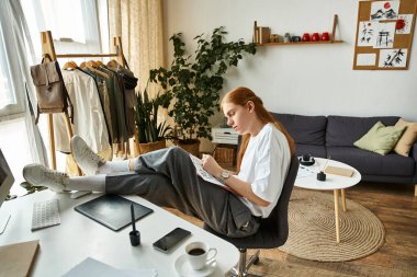 Genç bir adam, yeşillik ve doğal ışıkla dolu şık bir çalışma alanında sanat yaratıyor..