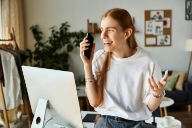 Genç bir adam masasında otururken enerjik bir telefon görüşmesi yapar..