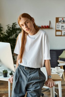 Parlak güneş ışığı, şık bir çalışma alanını doldurur. Genç bir adam gelişigüzel eğilir, düşüncelerini düşünür..