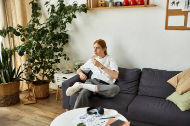 Genç bir adam yeşilliklerle dolu şık bir odada sükunetin tadını çıkarır..