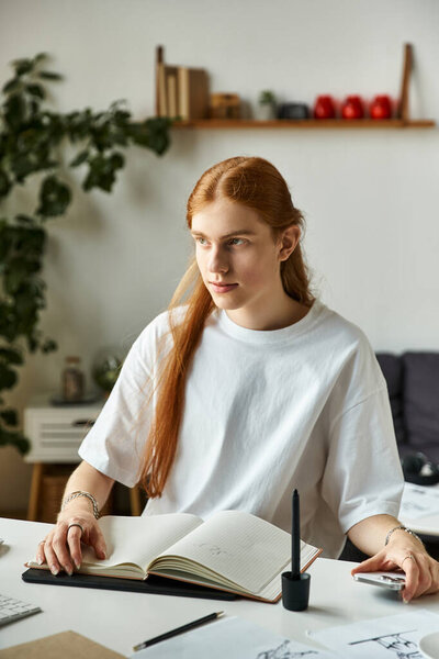 Концентрация наполняет комнату, когда молодой человек рисует идеи в своем уютном, творческом рабочем пространстве.