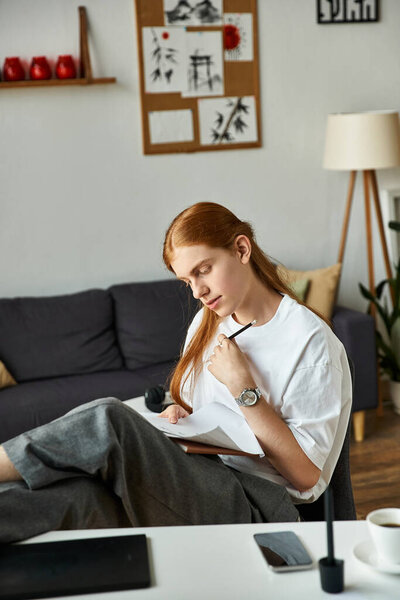 Молодой человек созерцает глубоко в окружении теплой, стильной обстановки интерьера.