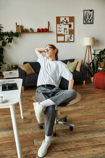 Молодой человек небрежно сидит в теплом, уютном пространстве, олицетворяя расслабление и комфорт.