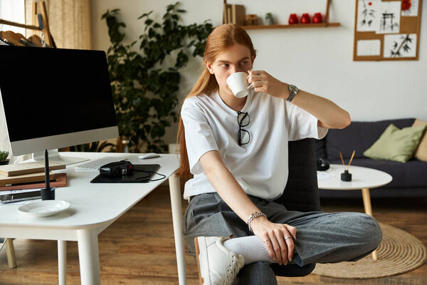 Молодой человек наслаждается теплым напитком, расслабляясь в уютной офисной обстановке.