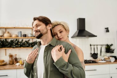 Bir çift, aşklarını ve ilişkilerini vurgulamak için davetkar mutfaklarında şefkatli bir kucaklaşmayı paylaşıyor..