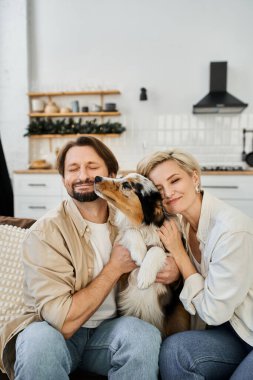 Sevgi dolu bir çift, içeride huzurlu bir anın tadını çıkarırken birbirlerini ve köpeklerini kucaklıyor..